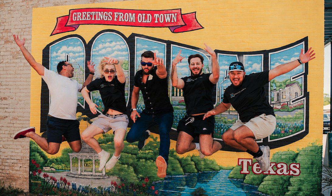 Heights Digital team at the Greetings from Old Town Boerne Texas mural — AI agency and digital marketing studio serving Boerne, San Antonio, Austin, and nationwide